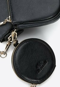 Schwarze Umhängetasche aus strukturiertem Kunstleder mit rundem, mit Reißverschluss versehenem Münzfach, goldfarbener Hardware und kleinem Logodetail.