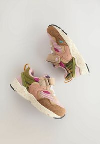 Baskets pour enfants en rose, marron, vert et beige avec tissu texturé, brides velcro et semelles blanches mouchetées sur fond clair.