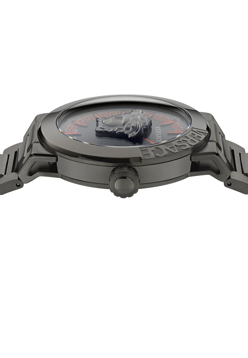 Orologio Versace con quadrante rotondo nero, logo con testa di leone, cassa in metallo grigio e bracciale. Presenta un motivo a chiave greca rossa attorno al quadrante.