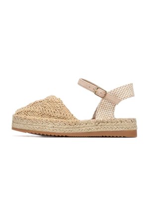 Sandalia alpargata beige con parte superior tejida, diseño triangular, detalles texturizados, correa ajustable en el tobillo y suela de yute trenzado.