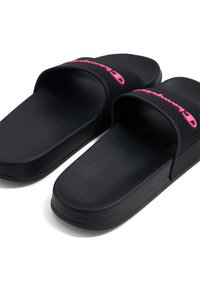 Las sandalias negras de tipo slide cuentan con una suela de goma texturizada, un diseño de punta abierta amplia y un acento de logo rosa en la correa.