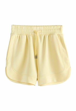 Jasnożółte, casual krótkie spodenki z elastycznym pasem, sznurkiem, bocznymi kieszeniami i zaokrąglonym detalem na dole, pokazane na białym tle.
