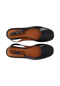 Μαύρα γυναικεία παπούτσια slingback από λουστρίνι με τετράγωνες μύτες και καφέ εσωτερικά, απεικονιζόμενα από πάνω σε λευκό φόντο.