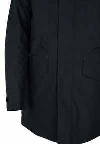 Chaqueta ligera y oscura con corte recto, dos grandes bolsillos frontales y puños ajustables. La tela tiene una textura suave y mate.