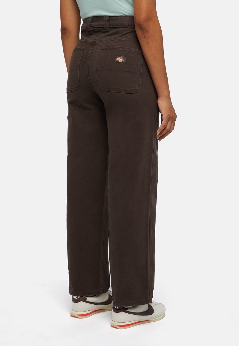 Bruine wijde cargobroek met achterzakken en logo-opdruk, met een hoge taille en een soepele stoftextuur. Gedragen met lichte sneakers.