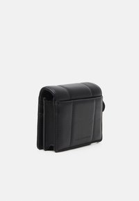 Portafoglio in pelle nera con design trapuntato, forma rettangolare compatta, dotato di chiusura a scatto e nome del marchio impresso di lato.