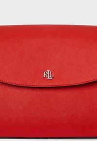 Červená texturovaná kabelka na clutch s kulatým víčkem a kovovým logem "RLL" na přední straně. Hladký povrch a elegantní design.