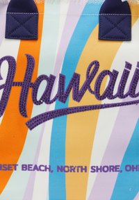 Színes vászontáska csíkos mintával narancssárga, kék és lila színekben. Az "Hawaii" felirat csillogó lila betűkkel van írva, tengerészkék díszítéssel.