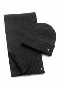 Black knit scarf and beanie set, featuring ribbed texture, compact design, and small metal logo accents. Material appears soft and warm.