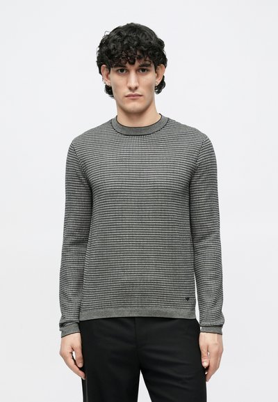 Fekete és szürke kötött kerek nyakú pulóver rácsmintával. Az anyaga puha tapintású, bordázott mandzsettákkal és egyenes szabással.