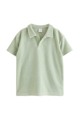 Lysegrøn kortærmet polo i frotté med åben krave og blød tekstur, vist fladt på en hvid baggrund.