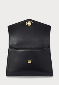 Black leather handbag with gold hardware, features a zippered pocket and a distinctive pentagon shape with a decorative logo.