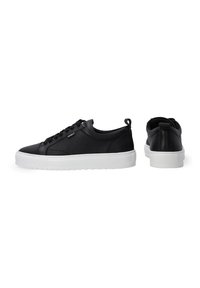 Schwarzer Sneaker mit einem strukturierten Lederoberteil, weißer Gummisohle, Schnürdesign und einer Zuglasche hinten für einfaches An- und Ausziehen.