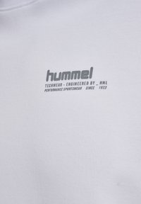 Weißer Stoff mit grauem "hummel"-Logo und dem Text "Techwear – Engineered by HML Performance Sportswear Since 1923".