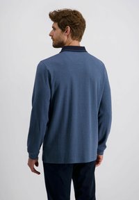 Langärmliges Polohemd für Herren aus strukturiertem, dunkelblauem Stoff mit einem kontrastierenden Kragen, seitlichen Schlitzen und einer lockeren Passform.