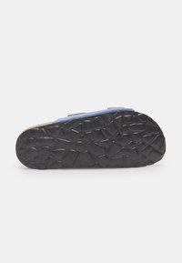 Sandal con tomaia in morbido suede blu, straps regolabili e suola in gomma nera texturizzata con motivi geometrici per una migliore aderenza.