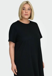 Czarna sukienka z krótkim rękawem, okrągłym dekoltem, luźnym krojem i gładką fakturą. Prosty design bez widocznych wzorów i zdobień.