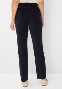 Navyblauwe corduroy broek met een recht gesneden pasvorm, voorzien van twee achterzakken en een ceintuur. Soepele textuur, casual stijl.