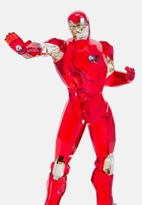 Crystal figurine of a red armored superhero. Features faceted surfaces, metallic accents, and clear details on the chest and palms.