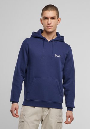 Marineblå hættejakke lavet af blødt stof. Har en kængurulomme, snøre i hætten og broderet "forever" logo på brystet.