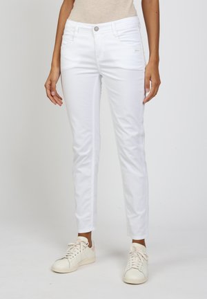 White denim jeans with a slim fit, mid-rise waist, front pockets, and a zipper fly. Smooth texture and single button closure detail.