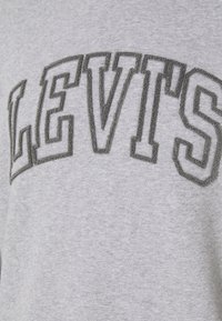 Sweat-shirt gris avec le mot "LEVI'S" en grandes lettres brodées gris foncé, en coton doux et texturé.