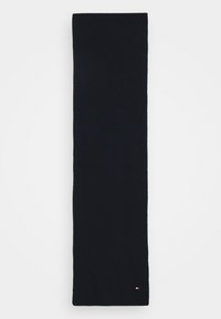 Marineblaue gerippte Strickschal, verlängerte rechteckige Form, mit einem kleinen Logo-Akzent in Rot, Weiß und Blau an einem Ende. Weiche Textur.