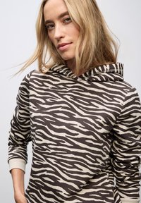 Bruine en crème gestreepte hoodie met een trekkoord in de capuchon en ribgebreide boorden. Gemaakt van zachte, textuurstof.