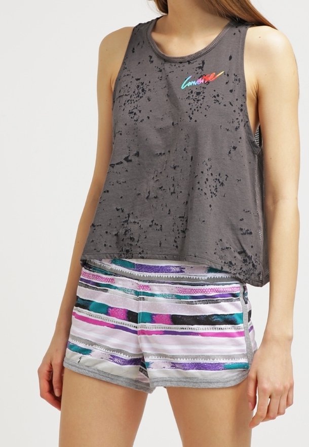 Top gris sin mangas con textura desgastada y logo "Converse" multicolor, combinado con shorts de rayas multicolores que presentan una cinturilla gris.