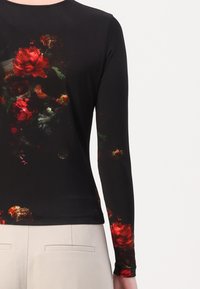 Schwarzes Langarmoberteil mit floralem Design aus roten Rosen und grünen Blättern, aus glattem Stoff gefertigt, mit einer figurbetonten Silhouette.