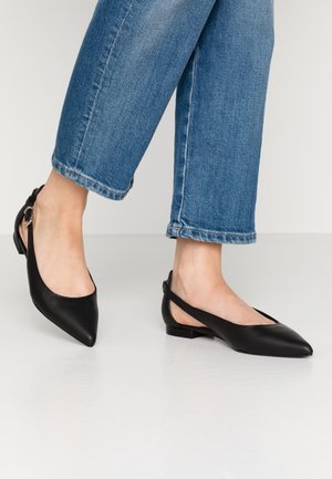 Czarne płaskie buty z wydłużonym noskiem i zapięciem na piętach, wykonane z gładkiej skóry. Posiadają niewielki obcas oraz boczny zamek pozwalający na regulację dopasowania.
