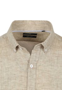 Linnen shirt in beige met een button-down kraag, met een gestructureerde stof en witte knopen. Label geeft aan dat het 100% linnen is.