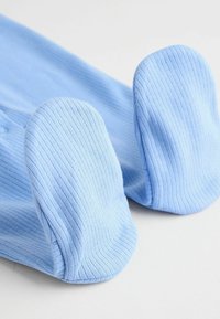 Tessuto a coste di un blu chiaro con piedi arrotondati e imbottiti. Le maniche si estendono dal tessuto centrale, mostrando una texture liscia.