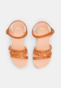 Ruske syntetiske sandaler med to brede stropper, der har cirkulære og trekanter studs, justerbar ankelrem og polstret sål.