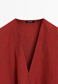 Rød linned top med V-udskæring, med en ren finish. Etiketten er synlig med mærkenavnet "Massimo Dutti," lavet i Portugal.
