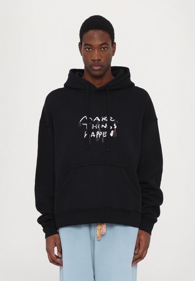 Black hoodie with a front pocket, drawstring hood, and white and pink graphic text "MAKE THINGS HAPPEN." Soft cotton material. Relaxed fit.