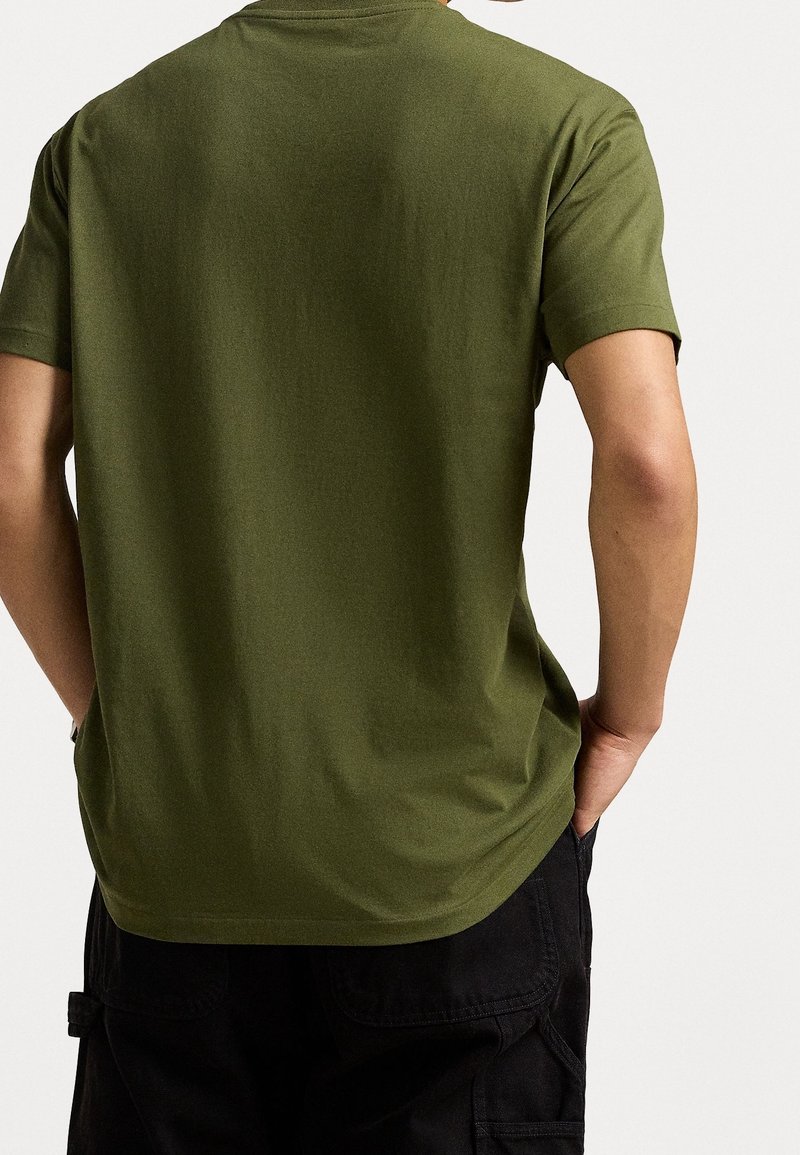 Olivgrön kortärmad t-shirt i mjukt tyg. Rakt snitt med rundad krage; minimal struktur och inga synliga mönster eller detaljer.