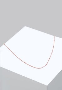 Colier din aur rose cu un design delicat al lanțului. Prezintă mici verigi rotunde și accente subtile de mărgele. Expus pe o platformă albă minimă.