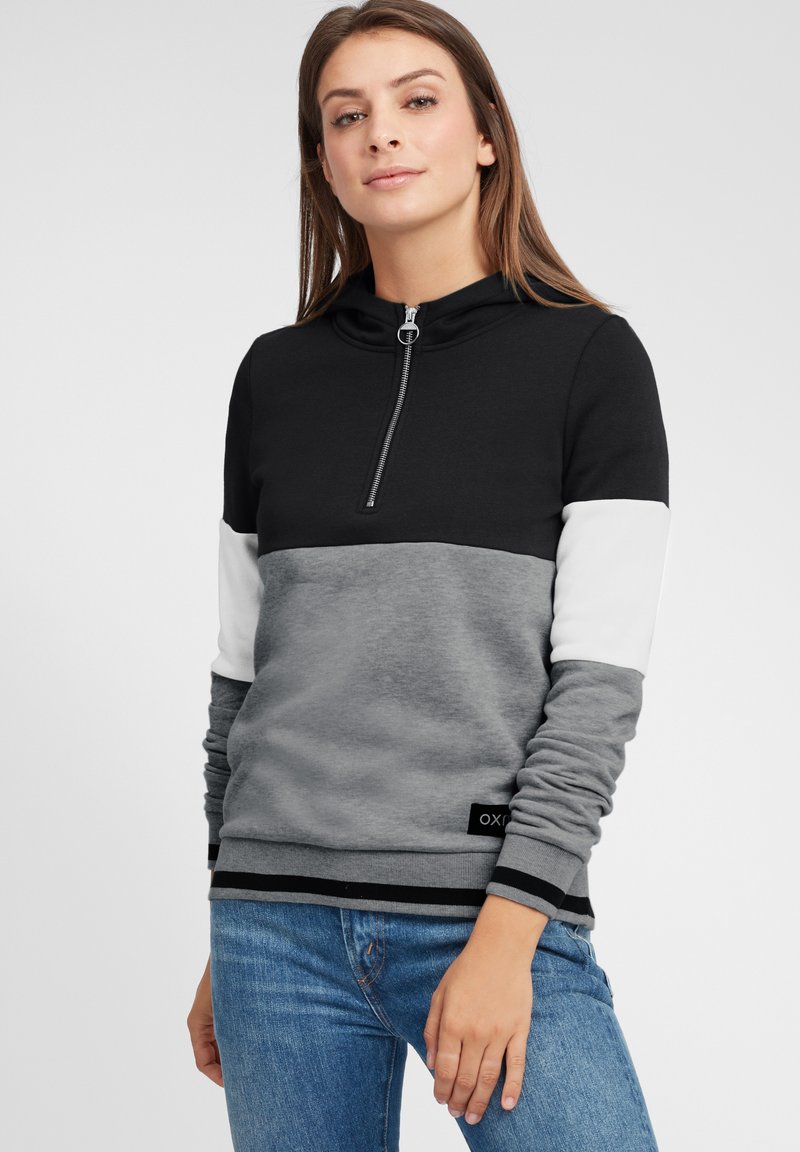 Svart och grå hoodie med halvveta, med en färgblockdesign. Mjuk tyg med kontrasterande vita ärmar och en märkesetikett i fållen.