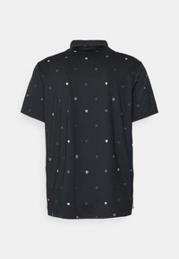 Le polo noir présente un motif répété de petits boucliers blancs et de croix, des manches courtes et un col classique.