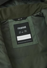 Groene geïsoleerde jas, binnenkant toont een zwart etiket van Reima met witte tekst, maat 92, en symbolen voor water- en koudebescherming.