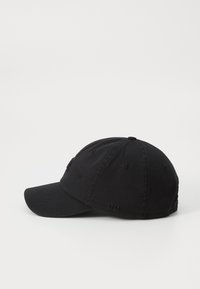 Black cotton baseball cap with a curved brim, six panels, embroidered eyelets, and a small logo on the front. Textured fabric surface.
