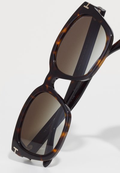 Tortoise shell sunglasses featuring a bold rectangular shape, dark tinted lenses, and silver logo accents on the arms.