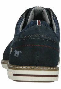 Scarpa scamosciata blu navy con tessuto testurizzato, cuciture rosse a contrasto e suola in gomma bianca. Presenta un piccolo logo di un cavallo grigio sul lato.