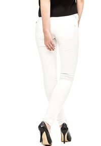 Jeans blancos ajustados con bolsillos, que muestran una silueta ceñida y una textura suave. Estilizados con tacones altos negros, con un acabado brillante.