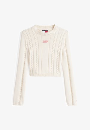 Suéter recortado color crema con patrón de trenzado, puños y cuello acanalados. Logo rojo de "tommy jeans" en la parte frontal. Tejido suave y texturizado.