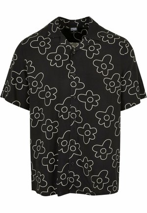 Camisa negra de manga corta con patrón floral blanco, que cuenta con un cierre frontal de botones y un corte relajado. Fabricada con tela ligera.