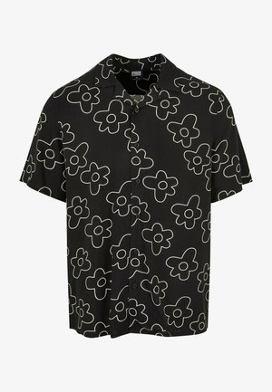 Camisa negra de manga corta con patrón floral blanco, que cuenta con un cierre frontal de botones y un corte relajado. Fabricada con tela ligera.