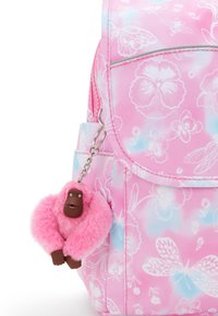 Zaino in tessuto rosa con motivi floreali e farfalle. Presenta un portachiavi a forma di scimmia rosa morbida attaccato a un cursore argentato.