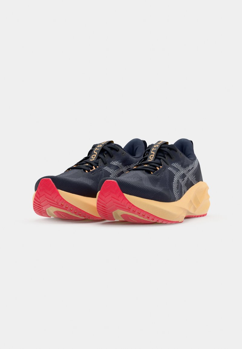Navy blue athletic shoes with a textured upper, contrasting yellow midsole, and red outsole. Features laces and a branded tongue.